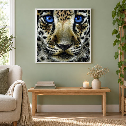 Leopardenbaby mit blauen Augen als gerahmtes Diamond Painting im Wohnzimmer