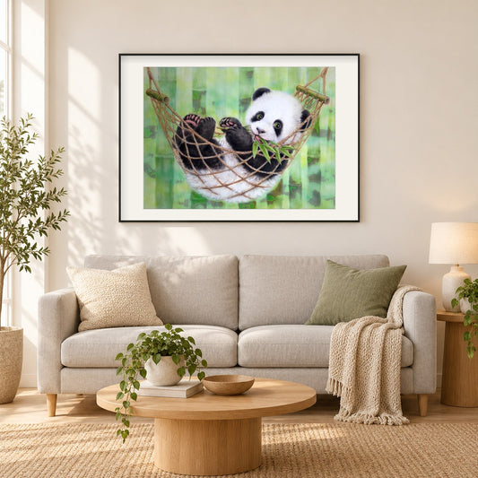 Panda ruht auf Hängematte als gerahmtes Diamond Painting im Wohnzimmer